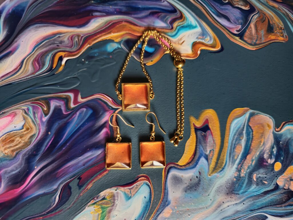 Gioielli artigianali set coordinato formato da bracciale e orecchini in acciaio inossidabile placcato color oro con cabochon in vetro quadrato e vernice acrilica color ambra e rame iridescente