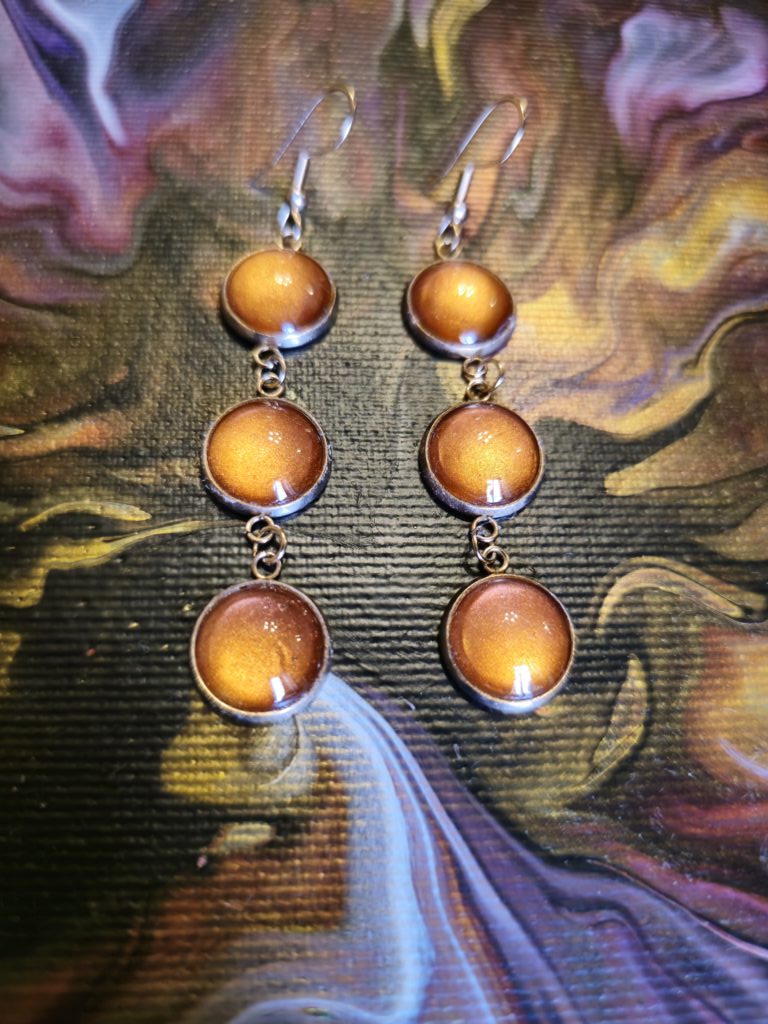 Orecchini artigianali fluid art in acciaio inossidabile golden rose, con tre cabochon rotondi in vetro 12mm gancio monachina vernice acrilica color ambra rame iridescente