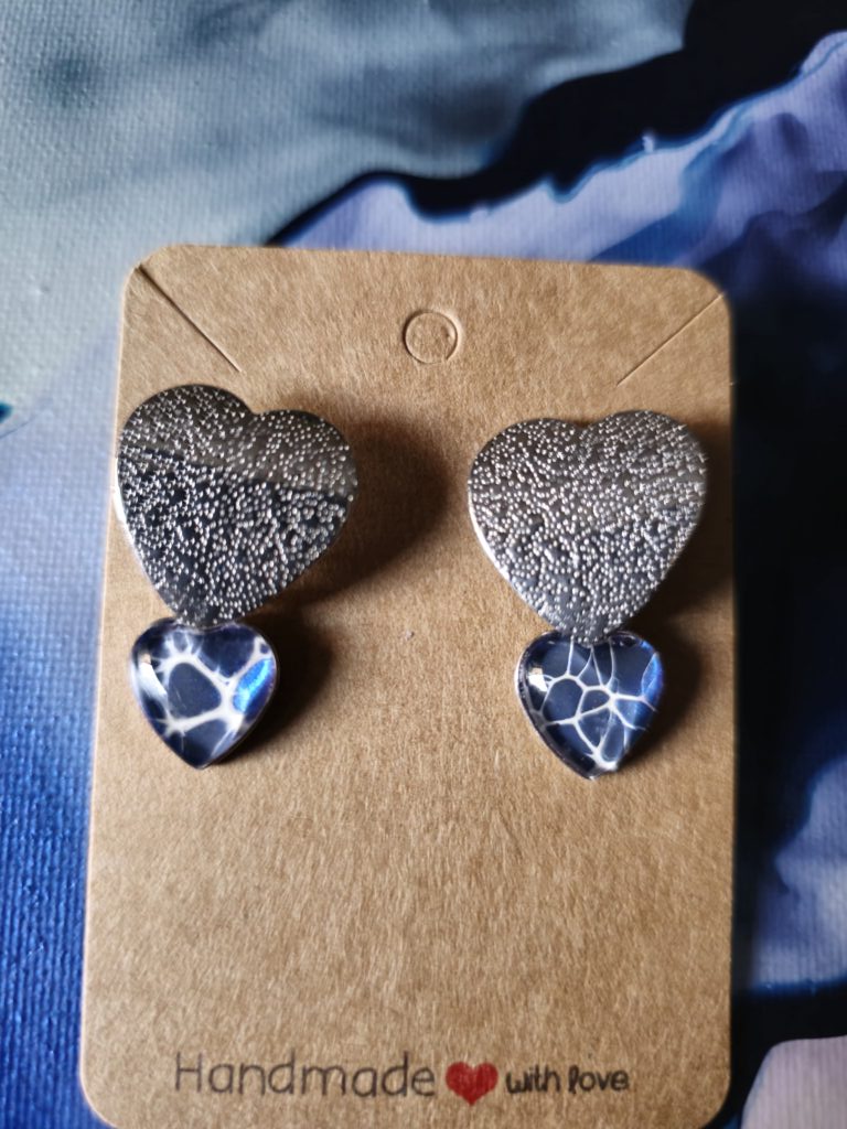 Orecchini artigianali fluid art in acciaio inossidabile, con cuore in acciaio e cabochon a forma di cuore in vetro 12mm gancio a farfallina, vernice acrilica blu iridescente e bianco