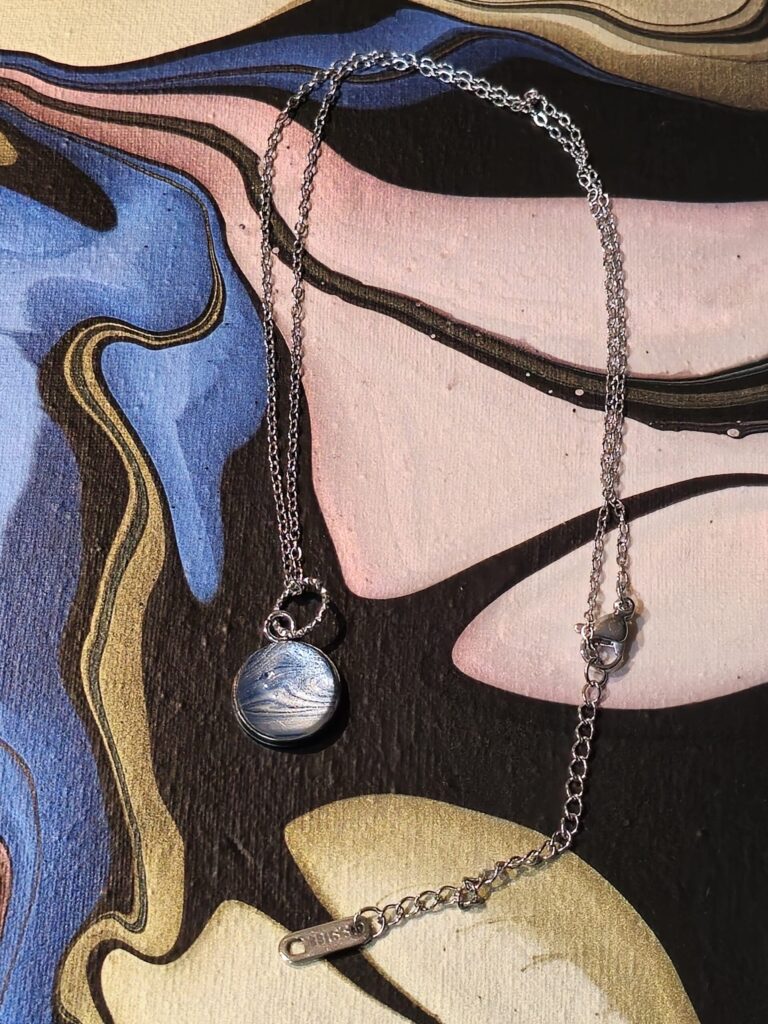 collana in acciaio inossidabile lungh.38,5cm, con pendente rotondo cabochon in vetro a cupola 12 mm, con vernice acrilica colori perlescenti azzurro e argento