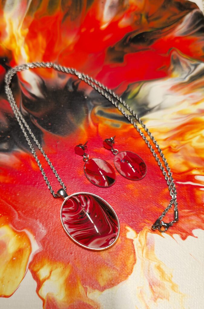collana artigianale fluid art con catena 70cm e pendente ovale 30x40 mm in acciaio inossidabili cabochon in vetro con vernice acrilica rossa fuoco nero,bianco. Autore AmarAnto Arte