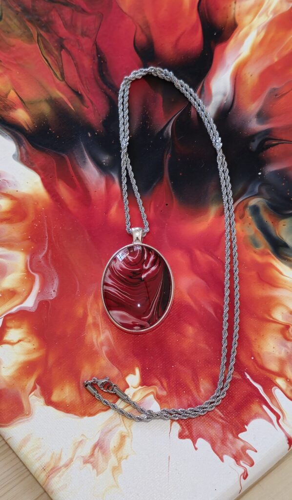 collana artigianale fluid art con catena 70 cm in acciaio inossidabile e pendente in lega ovale 30x40mm cabochon in vetro con vernice acrilica rossa fuoco nero,bianco. Autore AmarAnto Arte