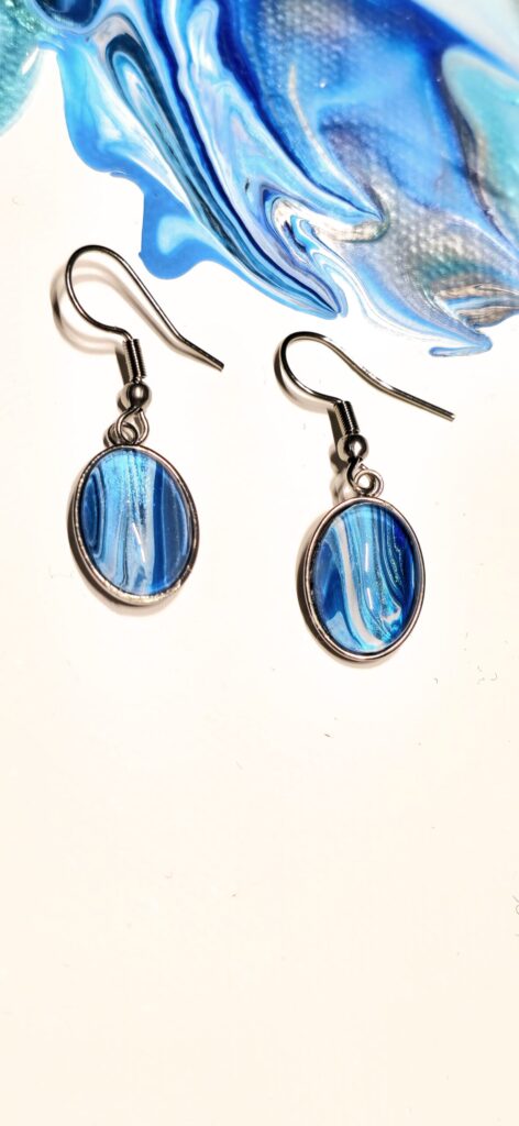 orecchini artigianali fluid art in acciaio inossidabile cabochon ovale in vetro 10x14mm colore vernice celeste blu perlescenti. autore AmarAnto Arte