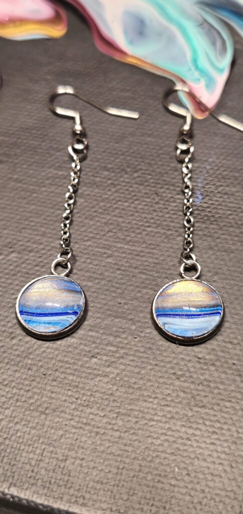 orecchini artigianali fluid art pendenti in acciaio inossidabile cabochon rotondo vetro 12mm vernice acrilica colore celeste, blu, oro iridescenti. autore AmarAnto Arte
