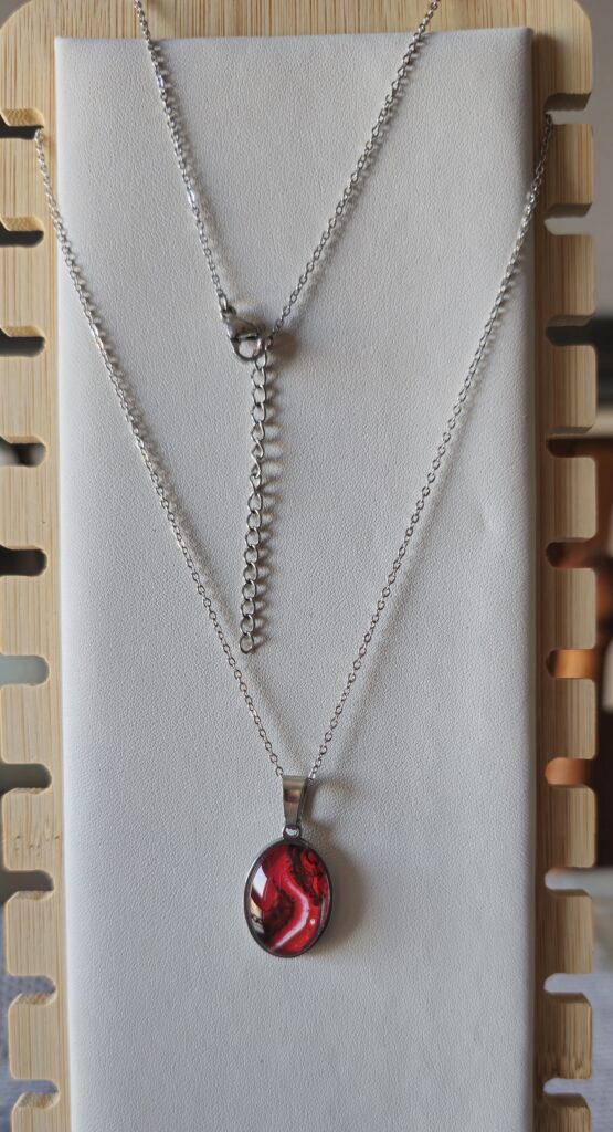 collana artigianale fluid art in acciaio inossidabile con ciondolo ovale in vetro e vernice acrilica color rosso bianco e nero.autore AmarAnto Arte