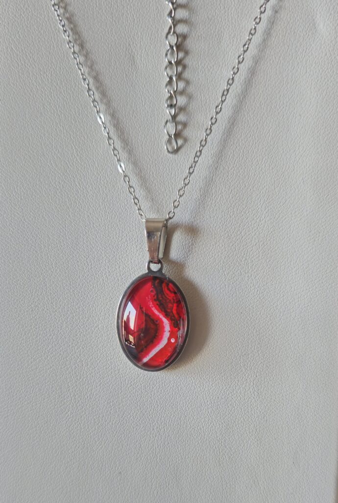 collana artigianale fluid art in acciaio inossidabile con ciondolo ovale in vetro e vernice acrilica color rosso bianco e nero.autore AmarAnto Arte