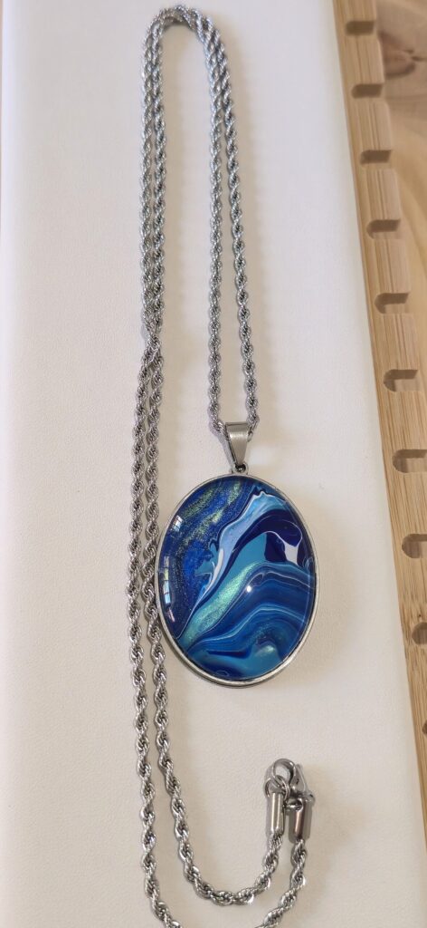 collana artigianale fluid art in acciaio inossidabile lunghezza 70 cm con ciondolo ovale 30x40mm color blu, celeste, turchese iridescenti. Autore AmarAnto arte