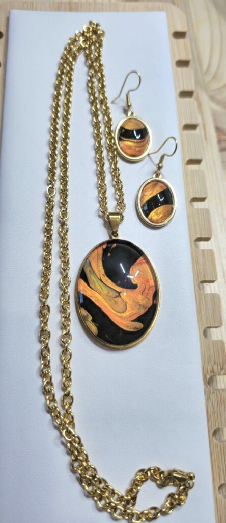 set coordinato artigianale fluid art collana e orecchini in acciaio inossidabile color oro con pendente collana ovale 30x40 mm e orecchini 13x18mmcolor oro, rame, bronzo e marrone. autore AmarAnto Arte