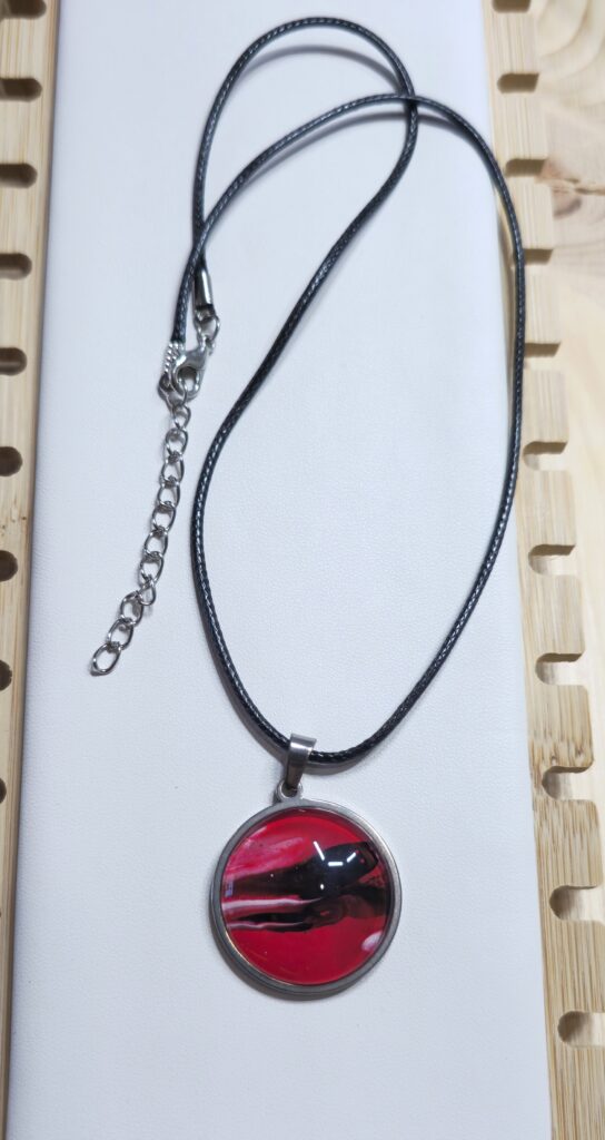 collana con pendente rotondo 20mm in acciaio inossidabile vernice acrilica effetto mare colore rosso nero e bianco. autore AmarAnto Arte