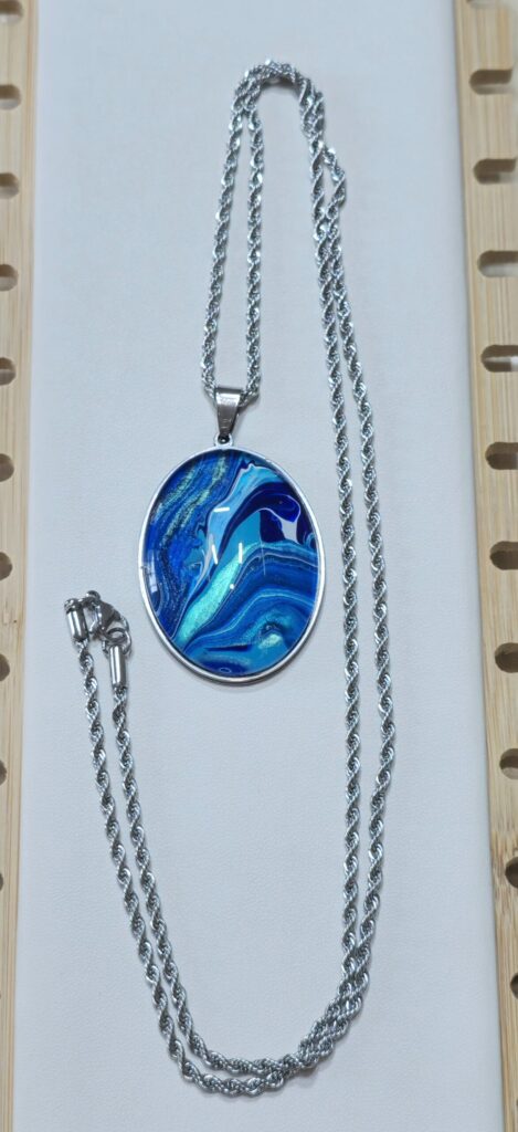 collana artigianale fluid art in acciaio inossidabile lunghezza 70 cm con ciondolo ovale 30x40mm color blu, celeste, turchese iridescenti.Autore AmarAnto Arte