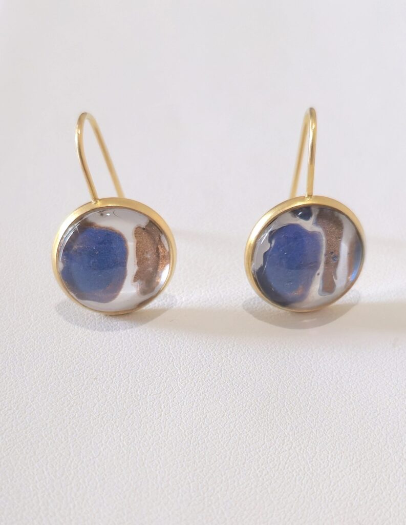 orecchini artigianali fluid art in acciaio inossidabile color oro e cabochon rotondo 12mm vetro e vernice acrilica blu, bianco e rame. autore AmarAnto Arte