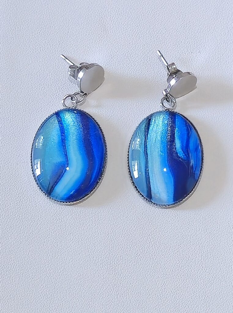 orecchini artigianali fluid art in acciaio inossidabile chiusura con farfallina cabochon ovale vetro 18x25mm vernice acrilica colore blu, turchese e celeste iridescenti. autore AmarAnto Arte