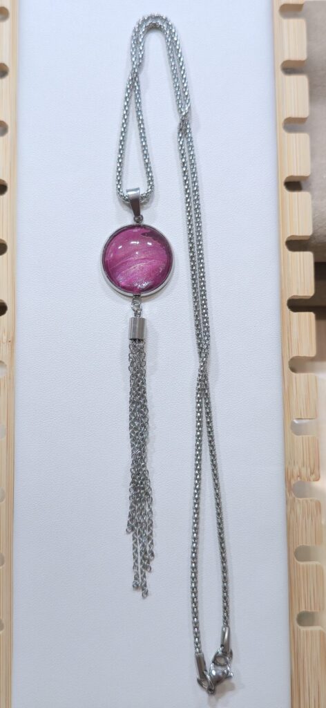 collana artigianale fluid art in acciaio inossidabile lunga 60cm con pendente rotondo in vetro 18mm, vernice acrilica amaranto rosa perlato con nappa in acciaio. autore Amar Anto