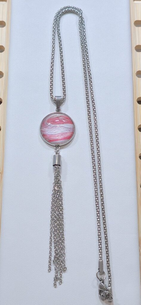 collana artigianale fluid art in acciaio inossidabile lunga 60cm con pendente rotondo in vetro 18mm, vernice acrilica rosa perlato e argento iridescente con nappa in acciaio. autore Amar Anto Arte
