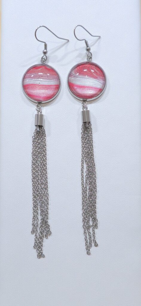orecchini artigianali fluid art in acciaio inossidabile con pendente rotondo in vetro 18mm, vernice acrilica rosa perlato e argento iridescente con nappa in acciaio. autore Amar Anto Arte