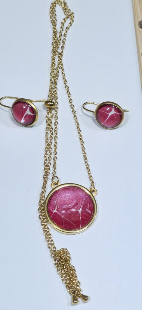 set coordinato collana artigianale fluid art saliscendi in acciaio inossidabile color oro con pendente rotondo 20mm, e orecchini rotondi 10mm, vernice acrilica rosso perlato e bianco. autore AmarAnto Arte