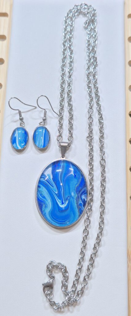 set collana artigianale con orecchini fluid art in acciaio inossidabile lunghezza 70 cm con ciondolo ovale 30x40mm color blu, celeste, turchese iridescenti. Autore AmarAnto Arte